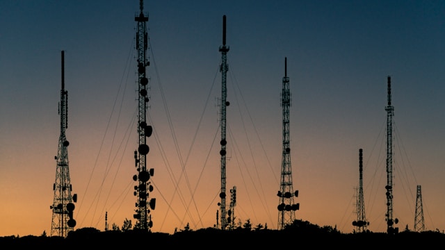 Radio communication towers and transmission masts at dusk representing wireless networks, radio frequency technology, and RF security training.