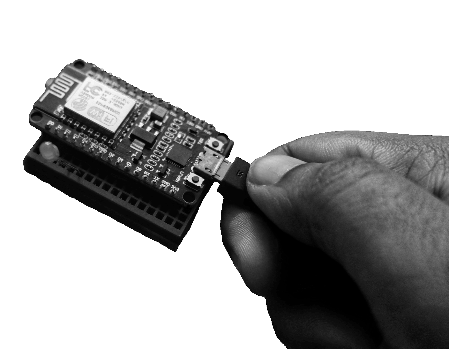 Hand plugging a Wi-Fi-enabled IoT microcontroller into a development board for embedded device testing and hardware security research.